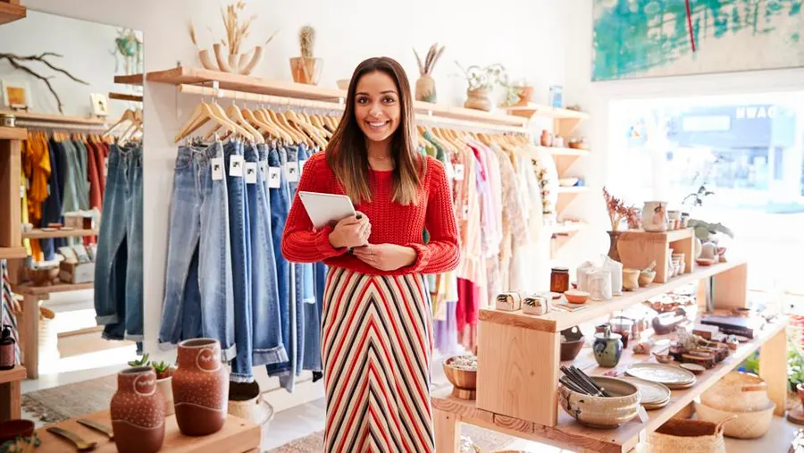 Shop owner holding a tablet in her boutique
